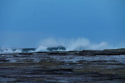 Scenic view of sea water splashing on rock formations