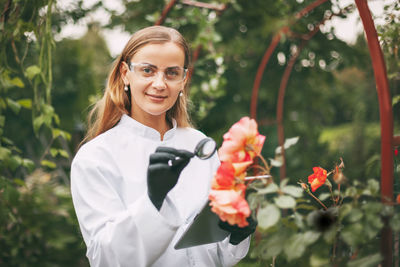 Portrait of a smiling young woman holding plant