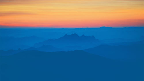 Scenic view of silhouette mountains against sky during sunset