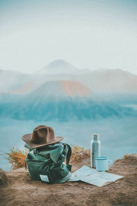 Woman reading book in desert against sky