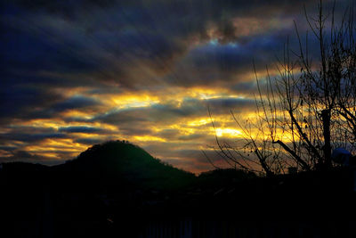 Silhouette of trees against dramatic sky during sunset