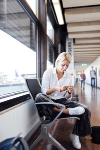 Woman using cell phone at airport