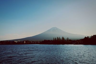 Scenic view of river and mountain against clear sky