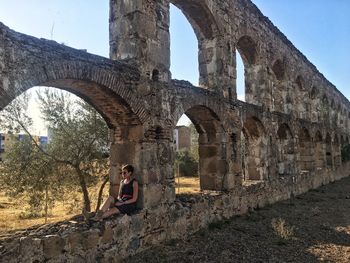 Woman sitting on old ruin