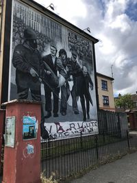 Graffiti on wall in city against sky