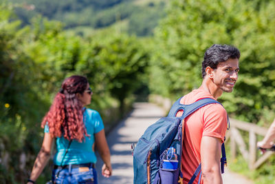 Side view of couple standing against trees