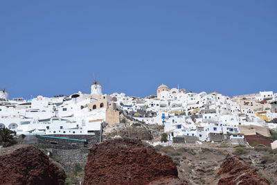 Buildings in town against clear blue sky