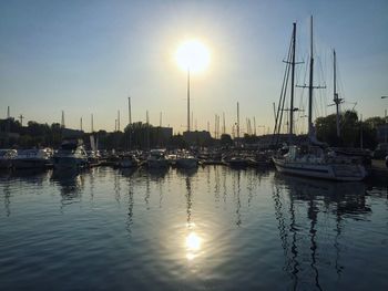 Sailboats in sea at sunset