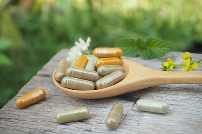 Close-up of capsules in wooden spoon on table