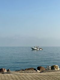 Sailboat on sea shore against sky