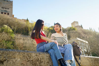 Side view of woman sitting on rock