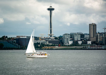Boats in river with city in background