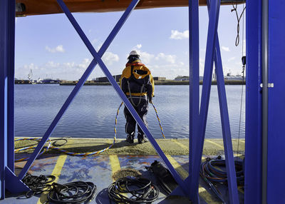 Man standing on boat in sea against sky