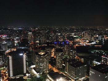 High angle view of illuminated cityscape against sky at night