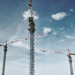 Low angle view of cranes against sky