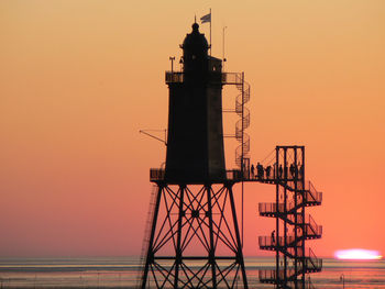 Silhouette of lighthouse against sky during sunset