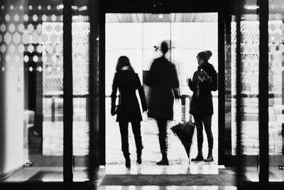 Rear view of silhouette people walking in corridor