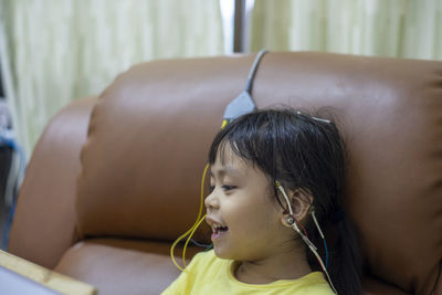 Cute girls with electrodes on head sitting on sofa