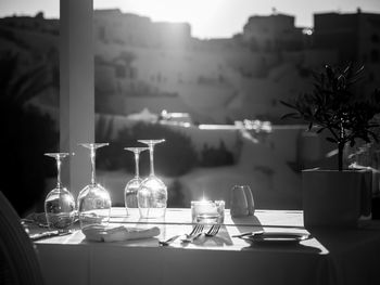 Restaurant table decorated with glasses on terrace in sunset light on the island santorini, greece