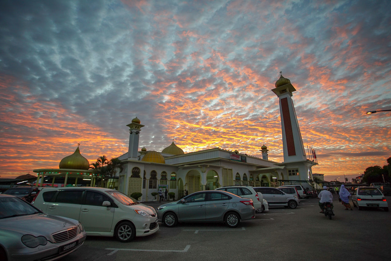 CARS IN CITY AGAINST SKY AT SUNSET