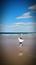 Children at beach against blue sky