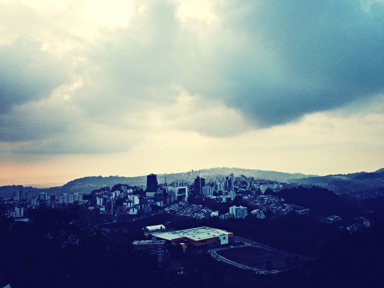 mountain, architecture, building exterior, built structure, sky, cloud - sky, mountain range, city, cityscape, cloudy, high angle view, cloud, weather, scenics, residential district, residential building, nature, landscape, crowded, outdoors