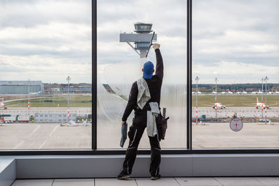 Man working at airport against sky