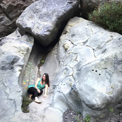 High angle view of woman sitting on rock