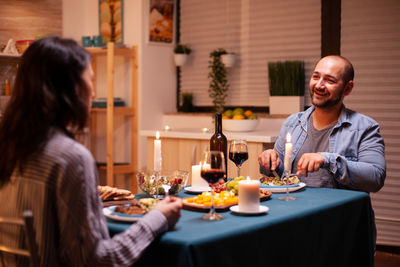 Portrait of smiling friends sitting at restaurant