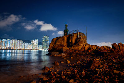 Buildings by sea against sky in city