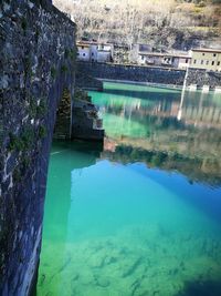 High angle view of swimming pool by lake against buildings