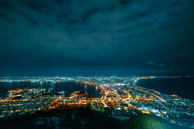 High angle view of illuminated cityscape against sky at night