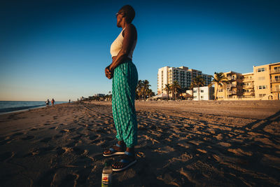 Full length of man on beach against clear sky