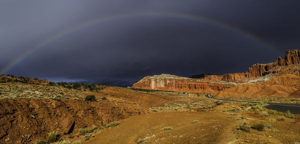 Scenic view of rainbow over mountain against sky