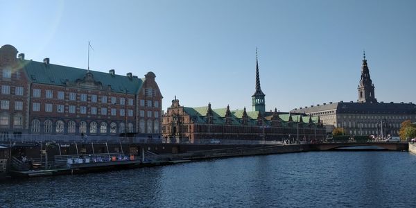 River by buildings against sky in city