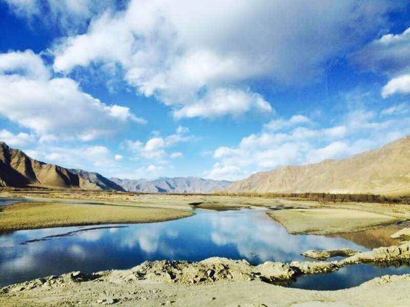 water, reflection, tranquil scene, lake, sky, cloud, tranquility, calm, blue, scenics, mountain, standing water, day, cloud - sky, beauty in nature, nature, non-urban scene, outdoors, majestic, waterfront, no people, remote, mountain range, solitude, surface level, rocky