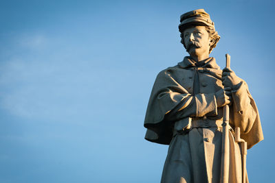 Low angle view of statue against blue sky