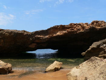 Rock formations by sea against sky