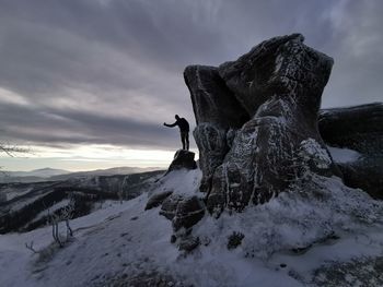 Person on snow covered mountain against sky