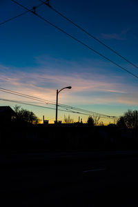 Electricity pylon against sky at sunset