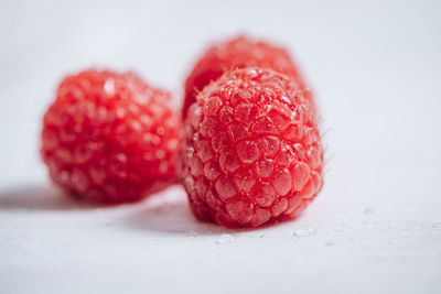 Close-up of strawberries on table against white background