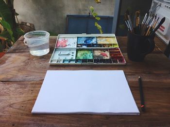 Close-up of canvas and watercolor paints on table