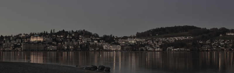 Panoramic view of lake by buildings against clear sky