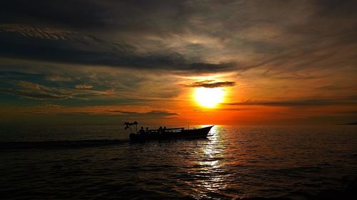 Silhouette boat in sea against sky during sunset