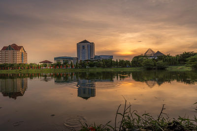 Reflection of buildings in lake during sunset