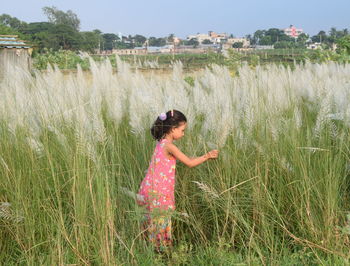 Side view of girl standing at field