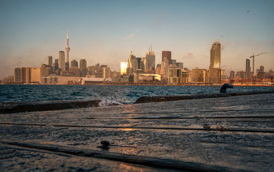 Buildings at waterfront during sunset