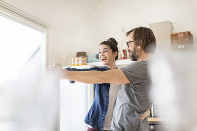 Playful couple dancing in kitchen