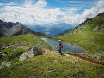 Rear view full length of boy on field against mountains