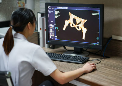 Rear view of woman working on table